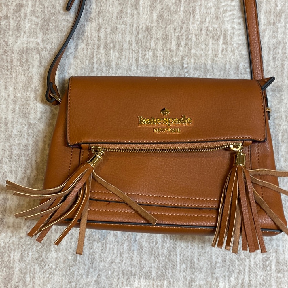 Kate Spade women’s brown leather purple lined fold over tasseled crossbody bag